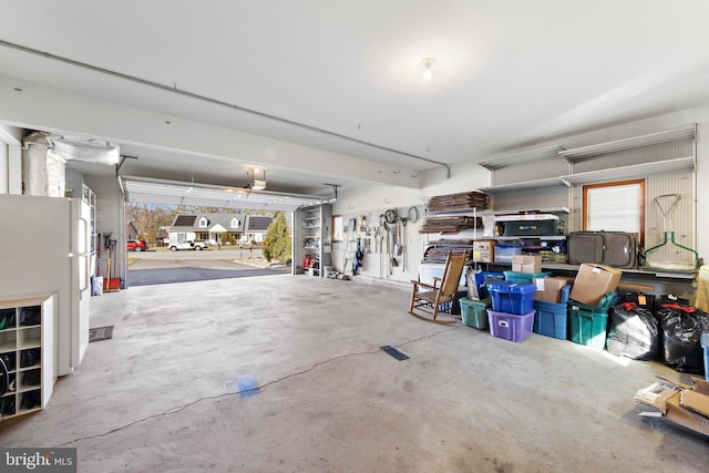 garage featuring a garage door opener and freestanding refrigerator