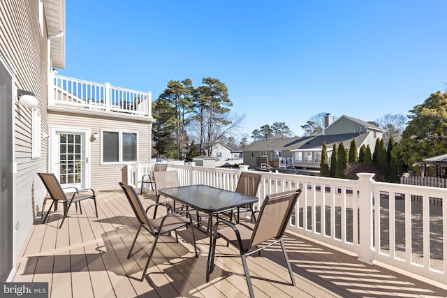 wooden terrace featuring a residential view and outdoor dining area