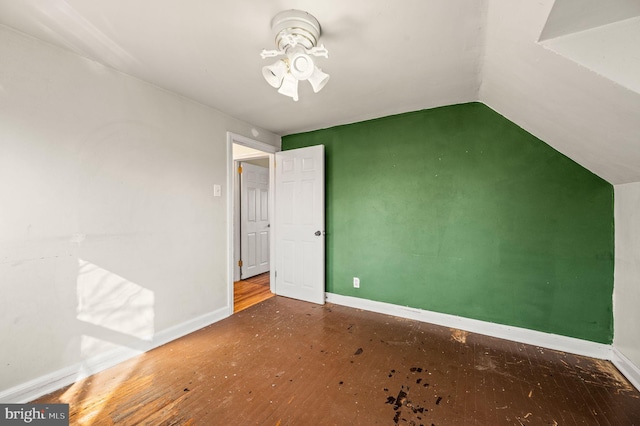 interior space featuring baseboards, lofted ceiling, and wood finished floors