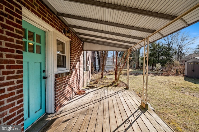 wooden deck featuring an outbuilding, a shed, a yard, and fence