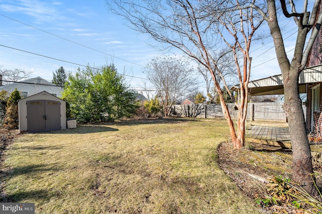 view of yard with an outbuilding, a shed, and fence