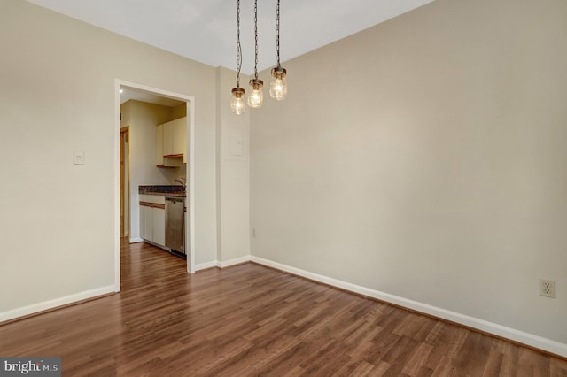 unfurnished room with baseboards and dark wood-style flooring