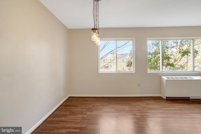 interior space featuring radiator heating unit, baseboards, and wood finished floors