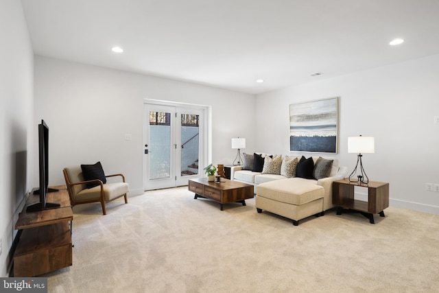 living room featuring recessed lighting, baseboards, and light carpet