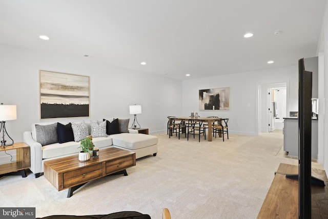 living area with recessed lighting, light colored carpet, and baseboards