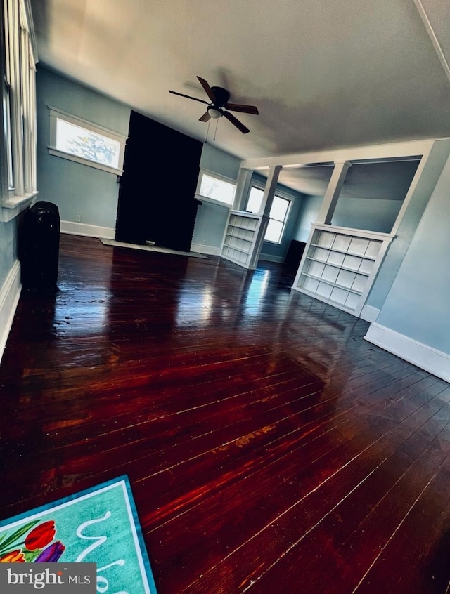 unfurnished living room featuring wood-type flooring, a healthy amount of sunlight, and ceiling fan