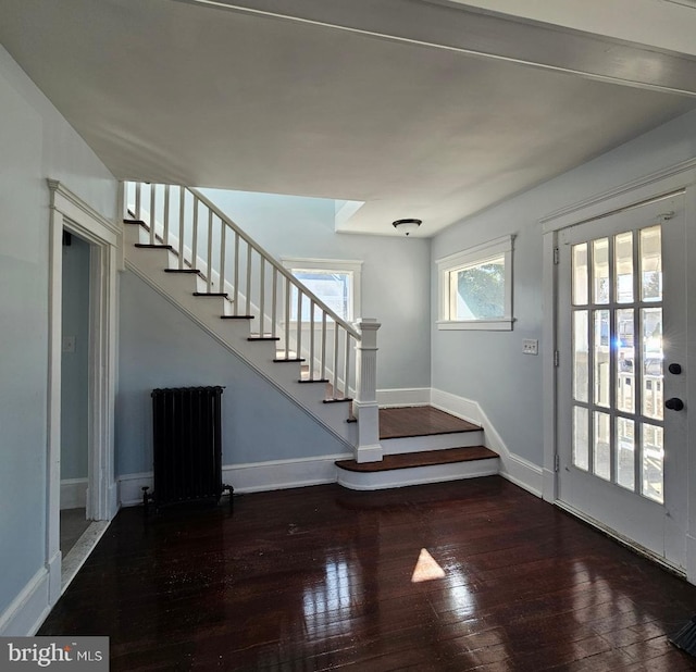 entrance foyer featuring baseboards, hardwood / wood-style floors, and stairs