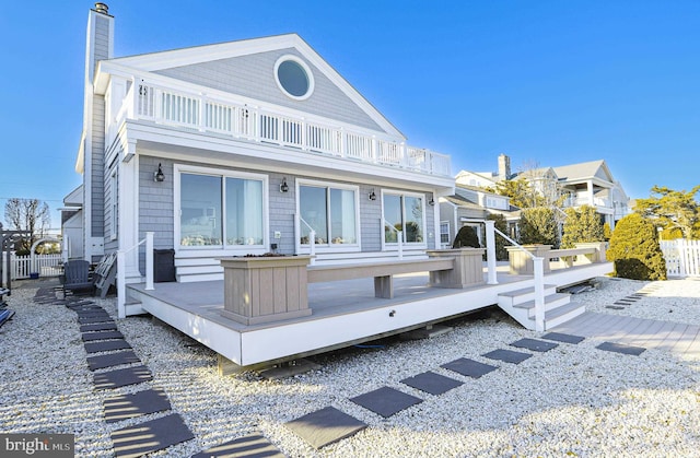 view of front of property with a balcony, fence, and a wooden deck