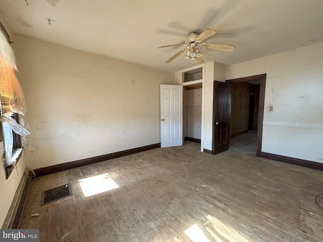 unfurnished bedroom with a ceiling fan, wood finished floors, baseboards, and visible vents