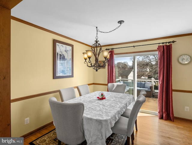 dining area with crown molding, light wood-style floors, and baseboards