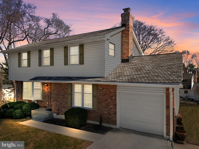 view of front of house with a garage, driveway, brick siding, and a chimney