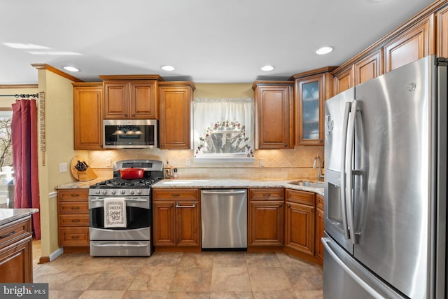 kitchen featuring stainless steel appliances, brown cabinets, and decorative backsplash