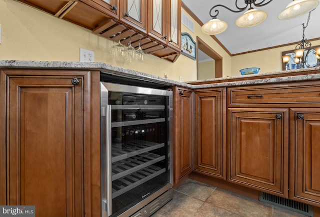 kitchen featuring beverage cooler, visible vents, brown cabinets, and crown molding