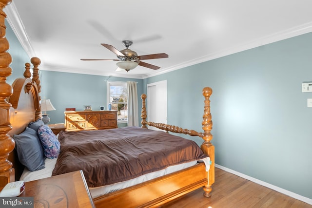 bedroom with ceiling fan, wood finished floors, baseboards, and ornamental molding