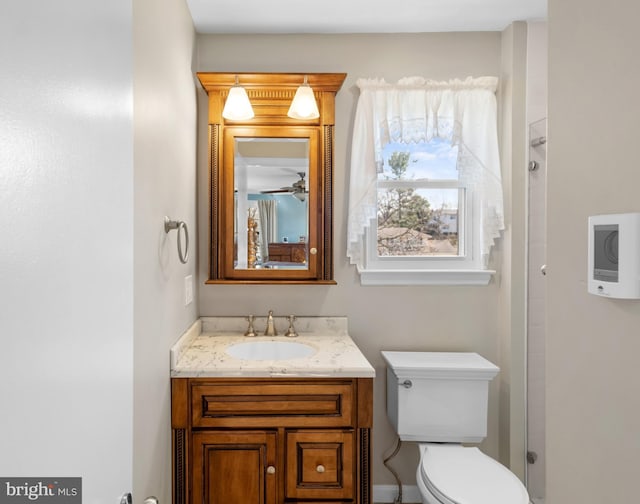 bathroom with toilet, walk in shower, and vanity