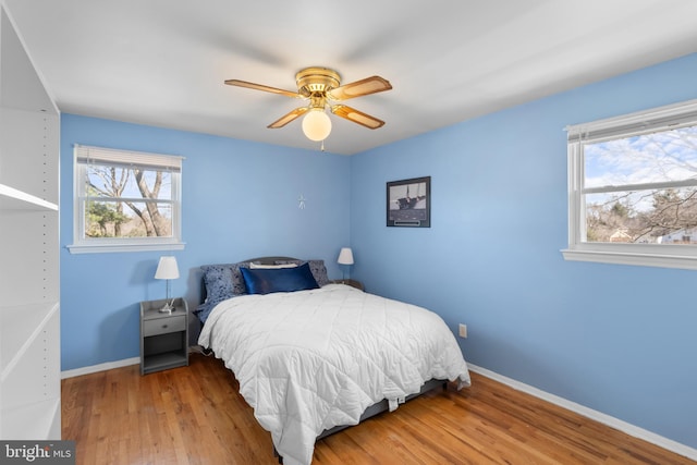 bedroom with ceiling fan, baseboards, and wood finished floors