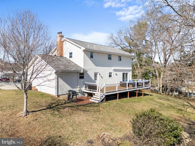 back of property featuring a garage, a lawn, a deck, and a chimney