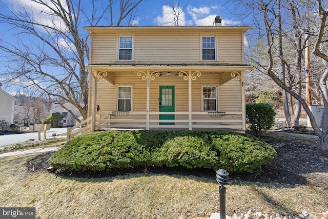 view of front of property featuring covered porch and a chimney