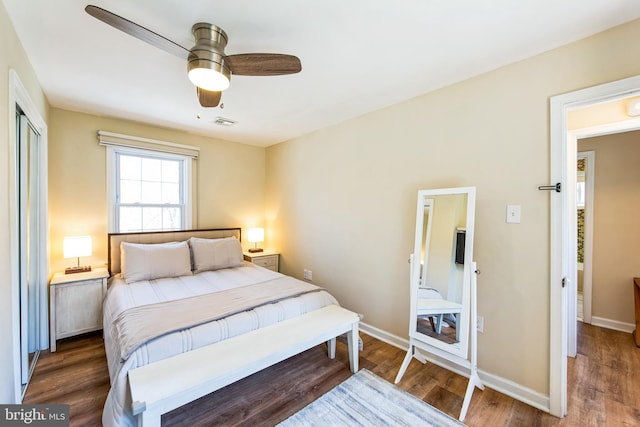 bedroom with wood finished floors, visible vents, and baseboards