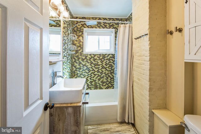 bathroom with vanity, shower / tub combo, toilet, and a wealth of natural light