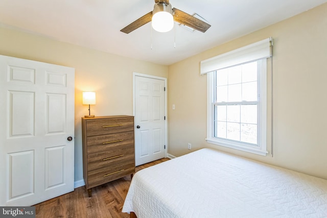 bedroom featuring dark wood-type flooring, baseboards, and ceiling fan