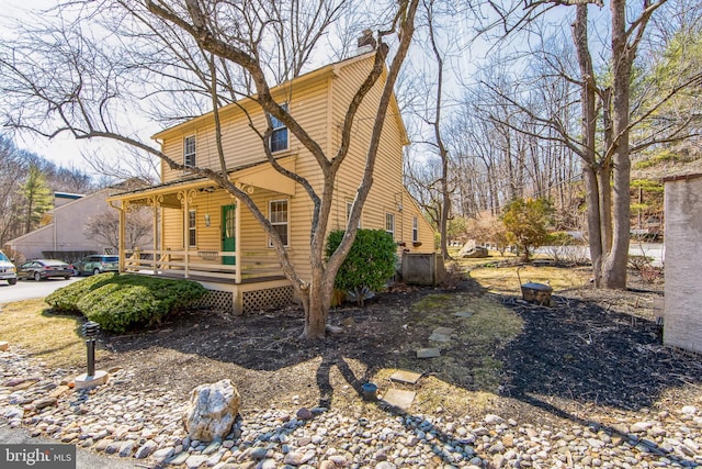 view of front of house with covered porch and a chimney