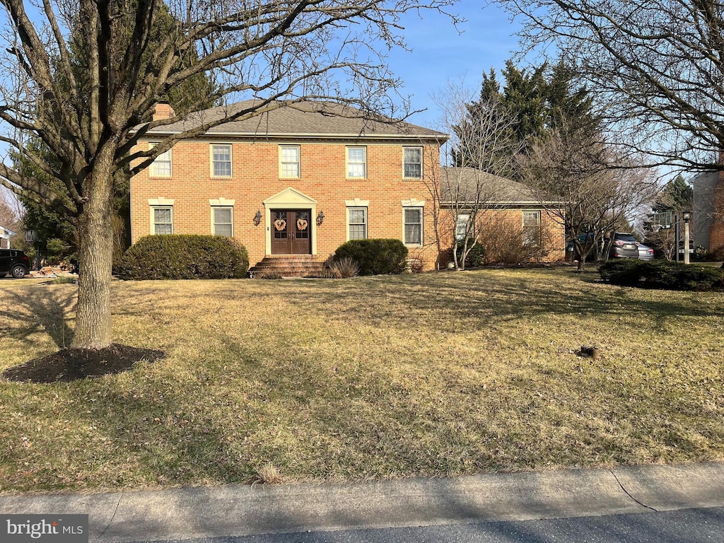 colonial house with brick siding and a front lawn