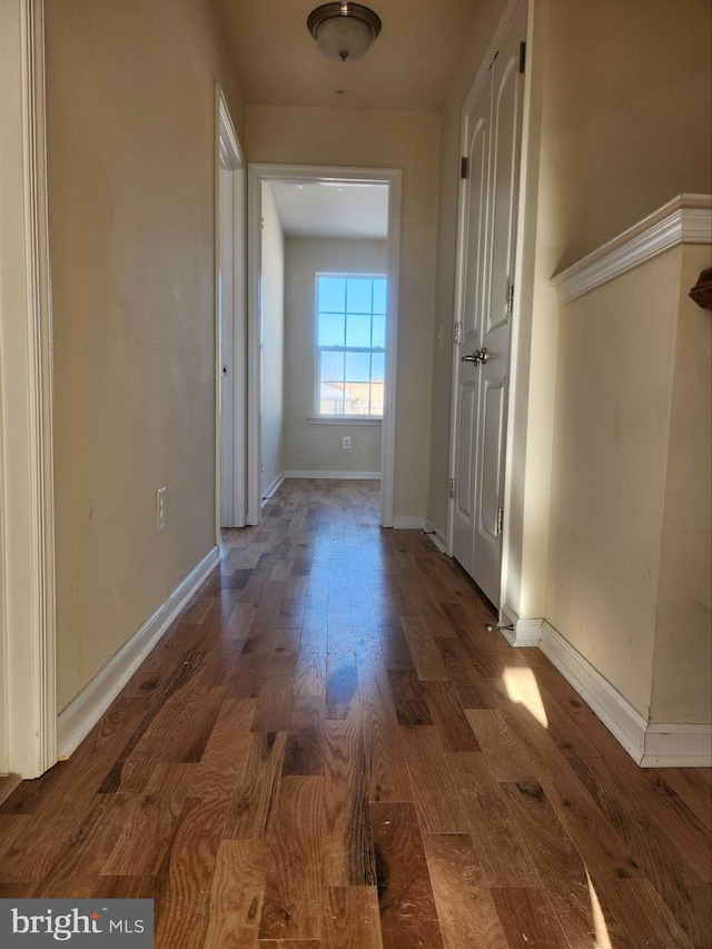 hall featuring baseboards and wood finished floors