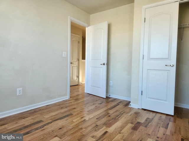 unfurnished bedroom featuring wood finished floors and baseboards