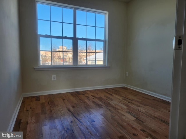 empty room with baseboards and wood finished floors