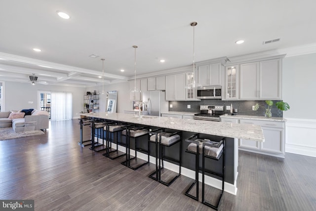 kitchen featuring a spacious island, visible vents, a kitchen breakfast bar, coffered ceiling, and stainless steel appliances