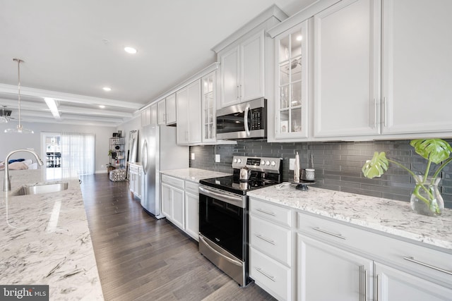 kitchen with decorative backsplash, white cabinets, appliances with stainless steel finishes, and a sink