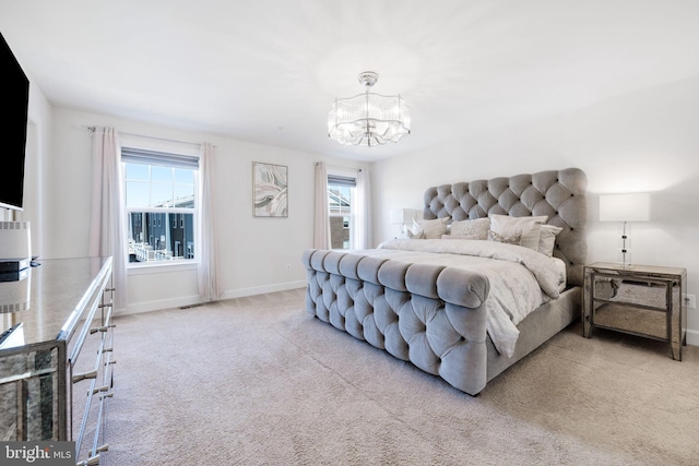 bedroom with an inviting chandelier, baseboards, and carpet