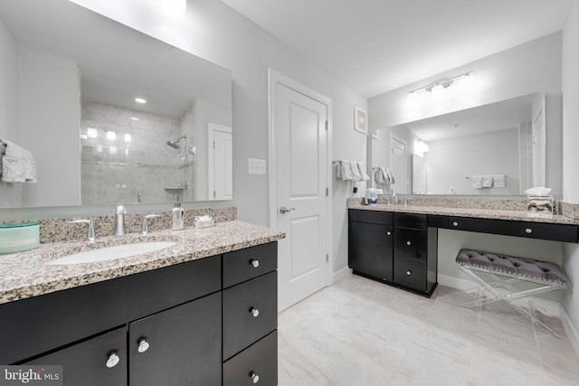 full bath with vanity, baseboards, and walk in shower