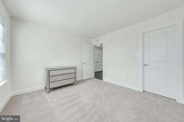 unfurnished bedroom with multiple windows, baseboards, and carpet floors