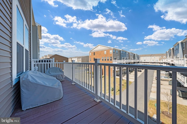 wooden terrace with a residential view and area for grilling