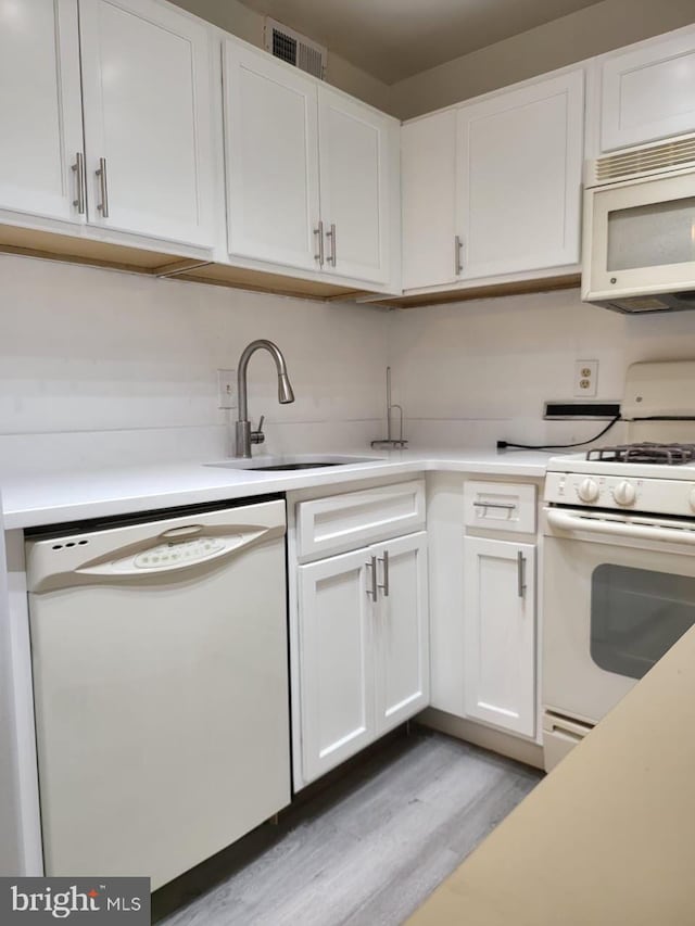 3100 S Manchester St Unit 909, Falls Church, VA 22044 - kitchen featuring a sink, white appliances, light wood finished floors, and white cabinets