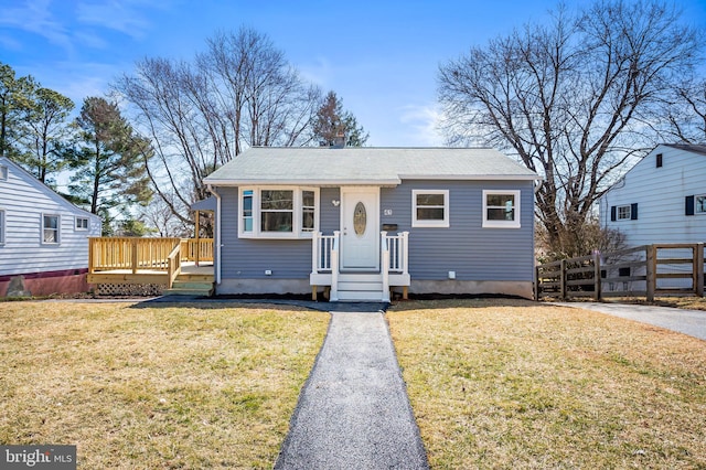 bungalow-style house with a wooden deck, a front yard, and fence