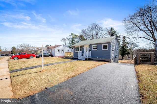 bungalow-style home with a front yard and driveway