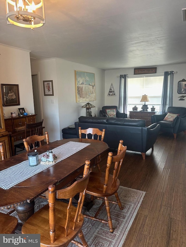 dining area with a notable chandelier, wood finished floors, and visible vents