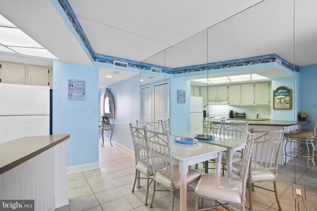 dining room featuring light tile patterned floors, visible vents, baseboards, and a toaster