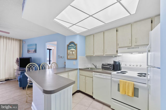 kitchen featuring under cabinet range hood, a sink, white appliances, a peninsula, and light tile patterned floors