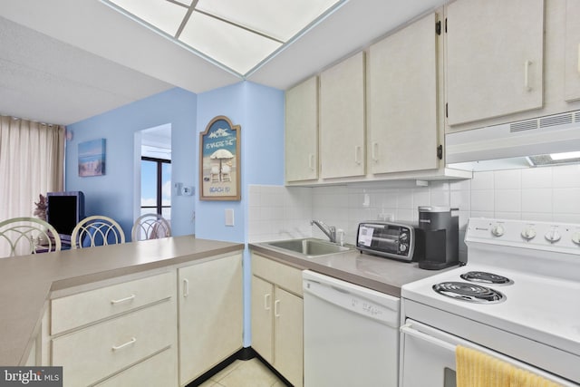 kitchen with white appliances, a sink, decorative backsplash, light countertops, and under cabinet range hood