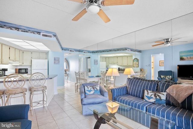 living room with light tile patterned flooring, a ceiling fan, and visible vents