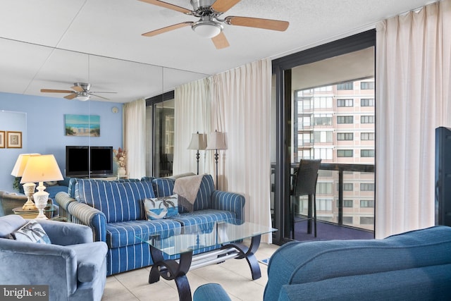 living room with a wall of windows, light tile patterned floors, and a ceiling fan