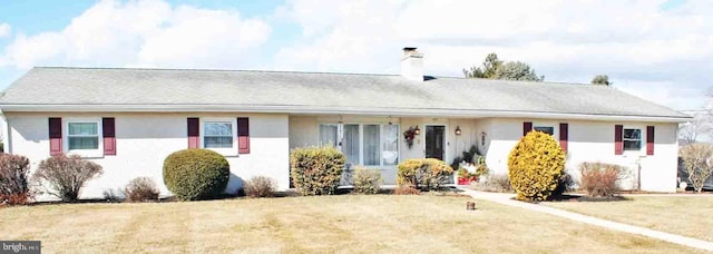 single story home featuring stucco siding, a chimney, and a front lawn