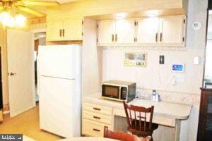 kitchen with stainless steel microwave, light countertops, and freestanding refrigerator