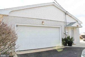 exterior space featuring aphalt driveway and an attached garage