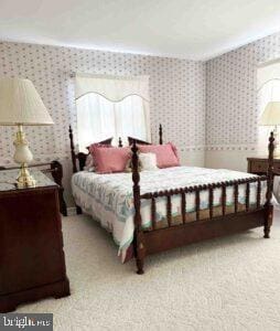 bedroom with wallpapered walls and carpet floors