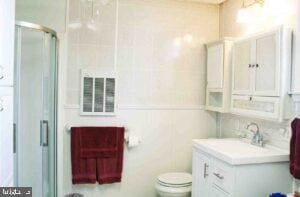 full bathroom with vanity, visible vents, a stall shower, tile walls, and toilet